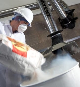 Stainless Steel Dust Extraction System used over a food tipping application in an ATEX zoned area as the dust can be seen being extracted through the arm to a larger dust collector unit.